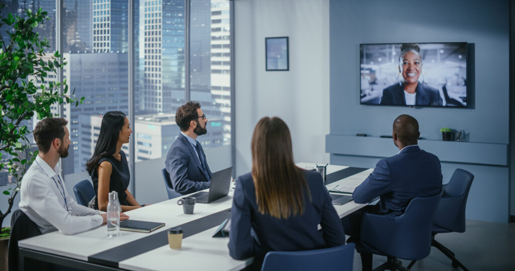 Video Conference Call in Office Meeting Room: Black Female Executive Talks with Group of Multi Ethnic Digital Entrepreneurs, Managers, Investors. Businesspeople Discuss e Commerce Investment Strategy